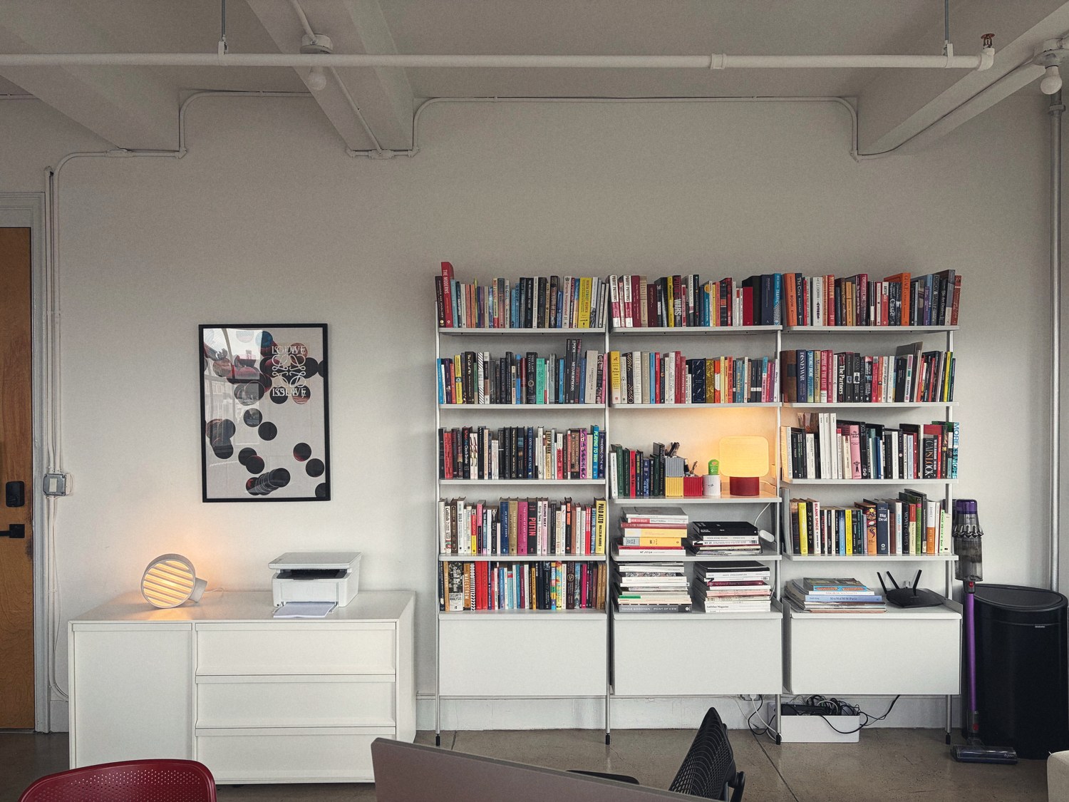 A wall of shelves in the Family Office studio, books stacked from design to geopolitics